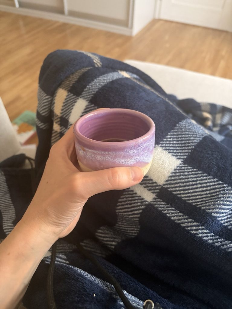 Hrnek čaje a deka jako symbol odpočinku a péče o psychickou pohodu.